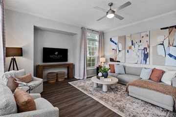 Tampa apartment for rent - A living room with a grey couch, a white coffee table, and a painting on the wall.