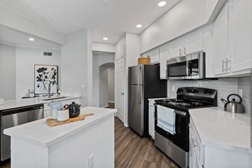 Tampa apartment for rent - A modern kitchen with white cabinets and stainless steel appliances.