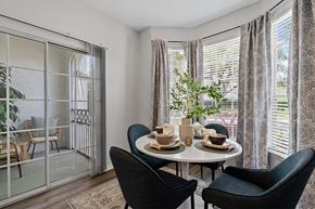 Tampa apartment for rent - A dining room with a table set for two and a view of a balcony.