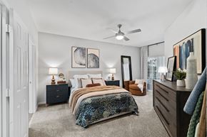 Tampa apartment for rent - A bedroom with a bed, dresser, and mirror.