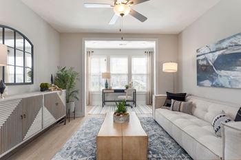 A living room with a white couch and a ceiling fan 