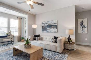A living room with a couch and a ceiling fan 