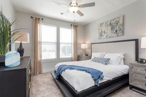 Bluffton apartment for rent - a bedroom with a large bed and a ceiling fan at Bristol at New Riverside, Bluffton, SC 29910