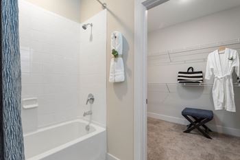 A bathroom with a tub and a shower and a towel rack