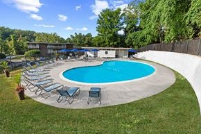 Baltimore apartment for rent - a pool with chairs and umbrellas around it at Brook View Apartments, Baltimore, 21209
