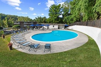 A pool with chairs and umbrellas around it