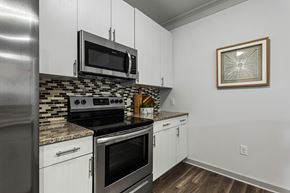 Charlotte apartment for rent - A kitchen with a stove top oven and microwave above it.
