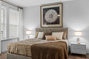 Charlotte apartment for rent - A bedroom with a large bed and a framed picture above it.