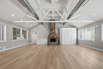 A large living room with a fireplace and wooden floors