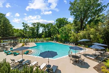 A swimming pool with umbrellas and chairs around it