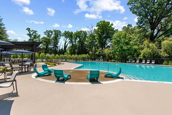 A swimming pool with umbrellas and chairs around it