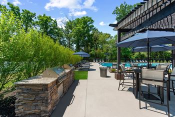 A patio with tables chairs and umbrellas and a pool