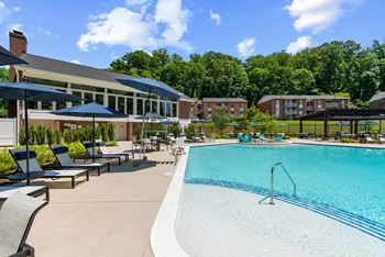 Resort style swimming pool with apartments and community center in the background