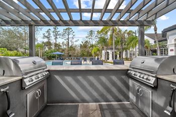 Pergola with two grills overlooking pool