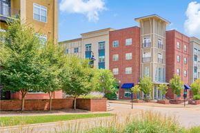 Asheville apartment for rent - A building with a red brick wall in front of it at The Lofts at Reynolds Village Apartments, Asheville, North Carolina