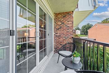 A patio with two chairs and a table on a balcony