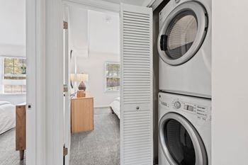 A small laundry room with a washing machine and a dryer