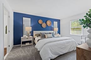 Towson apartment for rent - a bedroom with a bed and a blue wall at Courthouse Square Apartments, Towson, MD