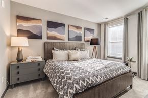Hanover apartment for rent - a bedroom with a bed and paintings on the wall at Dartmoor Place at Oxford Square Apartments, Hanover, Maryland