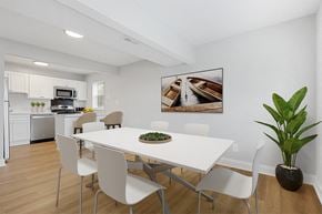 Parkville apartment for rent - a dining room with a white table and chairs and a white kitchen with stainless steel appliances Kenilworth at Perring Park Apartments, Parkville, MD 21234