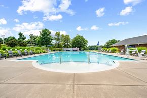 Parkville townhouse for rent - A large outdoor swimming pool surrounded by trees and a building.