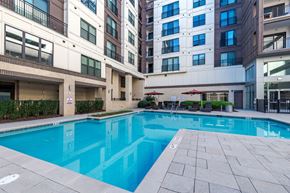 Raleigh townhouse for rent - A large swimming pool in front of apartment buildings at The Edison Lofts Apartments, Raleigh, NC, 27601