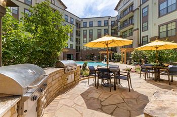 Grilling area with gas grills and patio seating with umbrellas