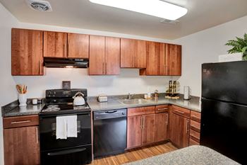 A kitchen with wooden cabinets and black appliances, 