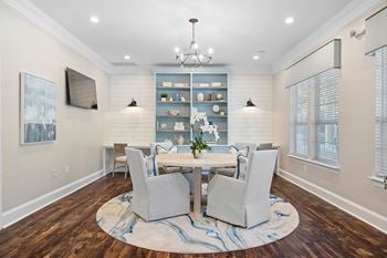 A dining room with a table and chairs and a tv