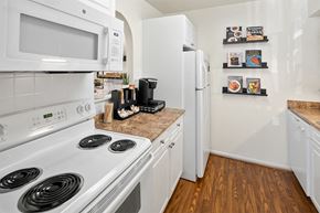 Owings Mills apartment for rent - a kitchen with white appliances and a white refrigerator at McDonogh Township Apartments, Owings Mills, MD