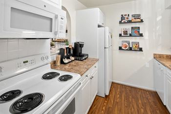 A kitchen with white appliances and a white refrigerator