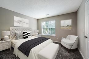 Raleigh apartment for rent - a bedroom with a bed and a chair at The Village Apartments, Raleigh, NC