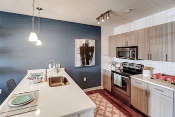 A kitchen with a white counter top and a sink.