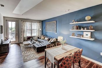 A living room with a blue wall and a wooden table.