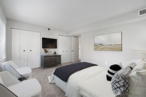 Baltimore apartment for rent - a bedroom with a large bed and a tv on the wall at Falls Village Apartments, Baltimore MD