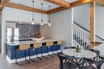 A kitchen with a blue island and a table with chairs