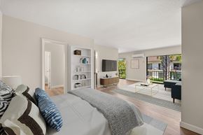 Miami Lakes apartment for rent - A bedroom with a large bed and a balcony overlooking the backyard.