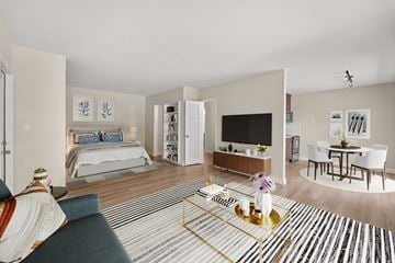 Miami Lakes apartment for rent - A living room with a grey sofa and a coffee table with a vase of flowers on it.