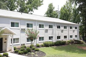 Marietta apartment for rent - a large white building with a lawn and trees in front of it