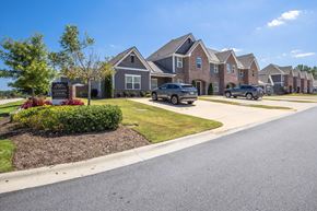 Opelika townhouse for rent - A row of houses with cars parked in front.