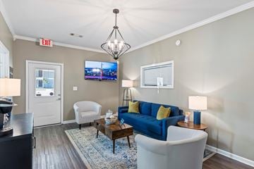 Auburn apartment for rent - A living room with a blue couch and a television on the wall.
