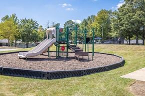 Auburn apartment for rent - A playground with a green slide and a red sign.