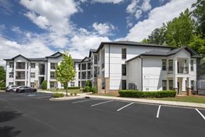 Homewood apartment for rent - A parking lot in front of a white apartment building.