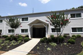 Marietta apartment for rent - a gray building with a sidewalk and trees in front of it