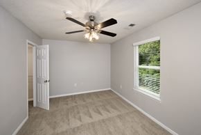 Perry apartment for rent - an empty bedroom with a ceiling fan and a window
