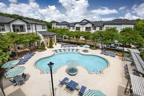 Homewood apartment for rent - A large swimming pool surrounded by lounge chairs and umbrellas.