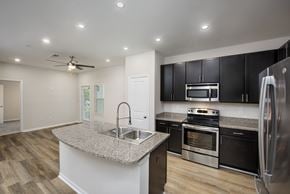 Homewood apartment for rent - A kitchen with black cabinets and stainless steel appliances.