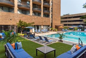 Arlington apartment for rent - a swimming pool with lounge chairs and a building in the background