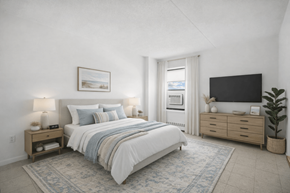 Far Rockaway apartment for rent - A bedroom with a large bed, a nightstand with a lamp, and a flat-screen TV mounted on the wall.