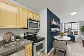 Arlington apartment for rent - A kitchen with wooden cabinets and a black stove top oven.